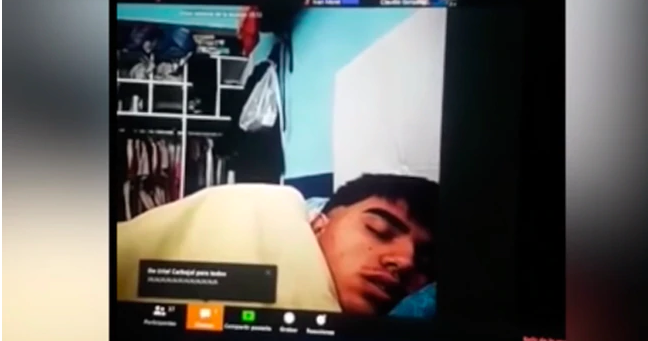 Captura de pantalla del video en el que el profesor comenta lo que pasó, apuntando a su alumno dormido (Facebook).