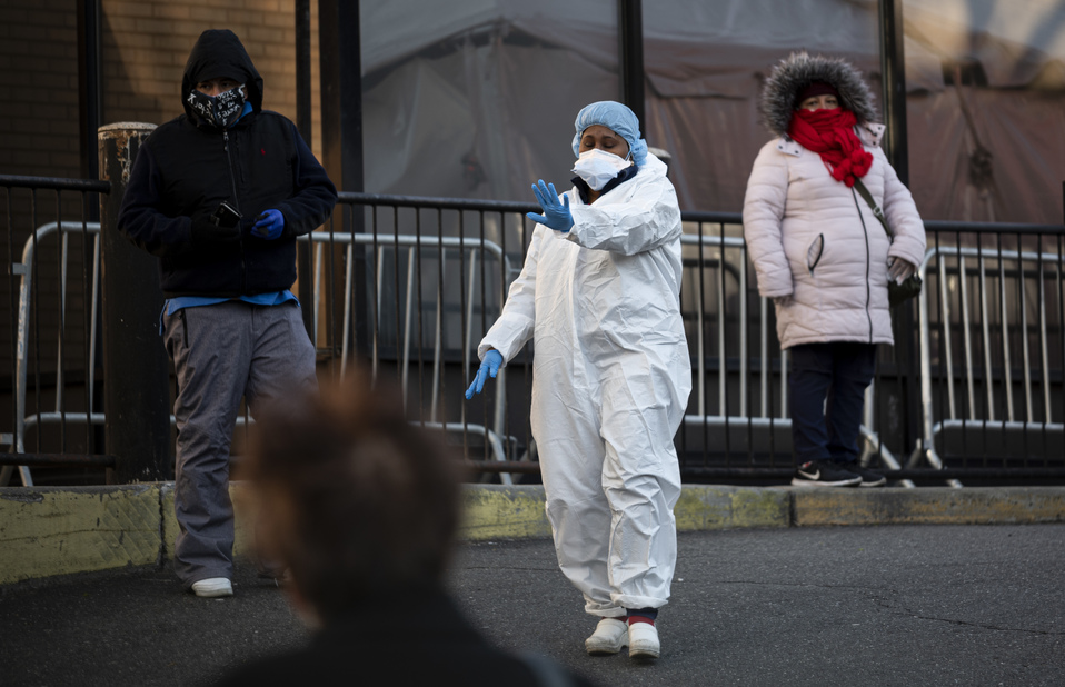 Trabajadora de salud en Queens solicita a las personas que tomen distancia durante pruebas de covid-19 en el condado. (AFP)