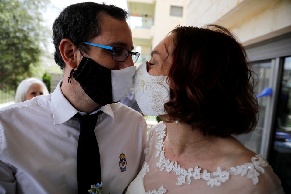 Esta pareja de Israel no perdió la elegancia en su boda al usar estos cubrebocas que combinan con su vestimenta. (Reuters)