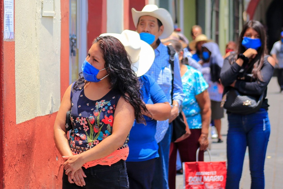 En Atlixco, personas hacen fila afuera de una institución bancaria sin guardar la sana distancia. (Andrés Lobato)