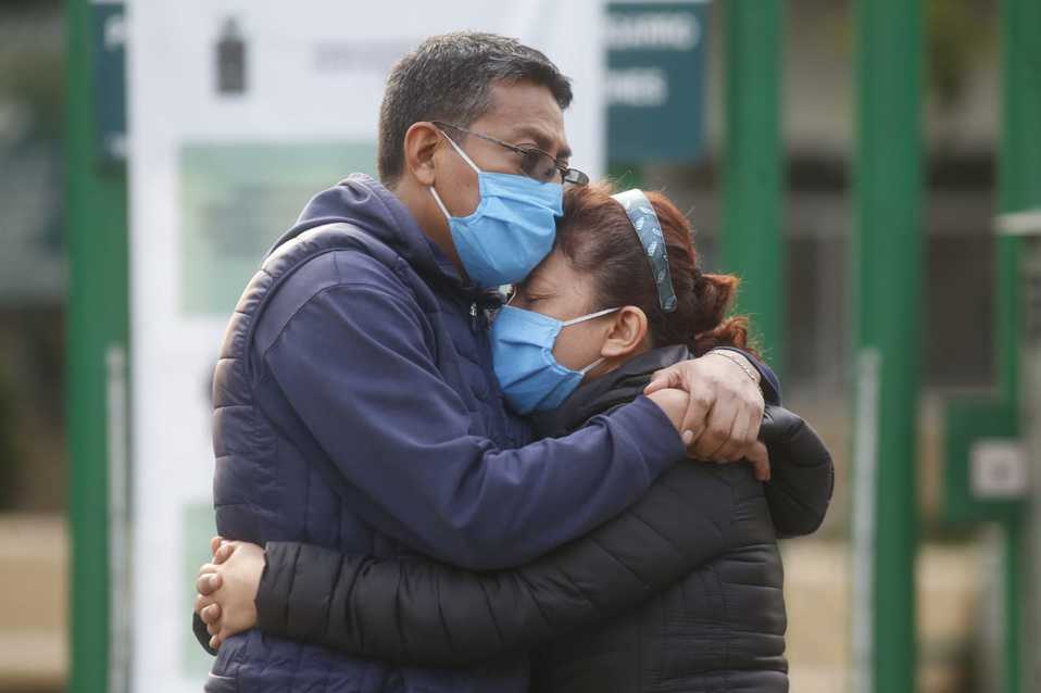 Una pareja se abraza frente a las puertas del Hospital Siglo XXI, durante la pandemia por coroanvirus. (Araceli López