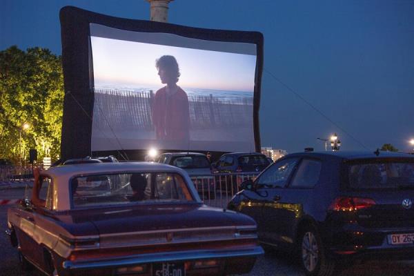 Franceses disfrutan una película desde sus autos en Burdeos. (EFE)