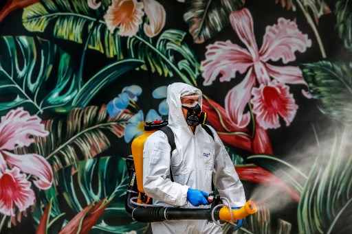 Un trabajador sanitiza un centro comercial en Caxias do Sul, Brasil. (AFP)