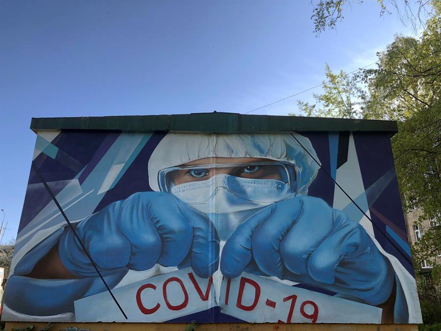 Un grafiti  retrata a un médico rompiendo un papel con el nombre de la enfermedad que ha sacudido a todo el mundo. (EFE)