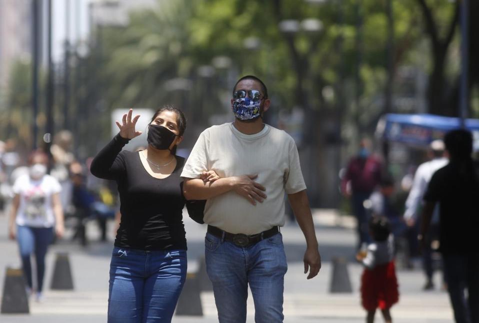 Capitalinos con cubrebocas camina en la calle mientras se toman del brazo. (Araceli López)