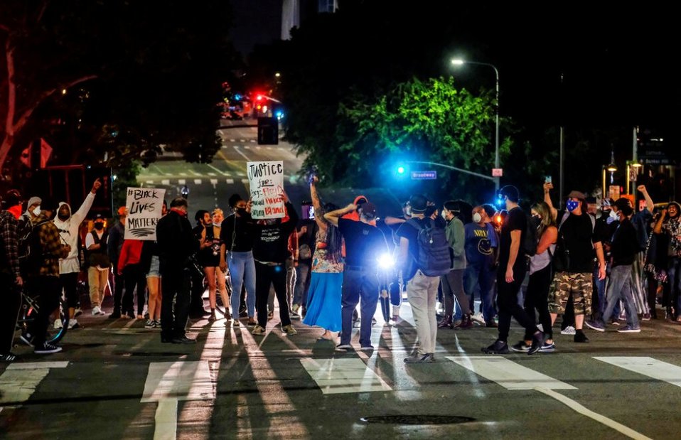 En el lugar donde Floyd fue arrestado, la gente cantaba y colocaba ramos de flores como tributo al fallecido. (AP)