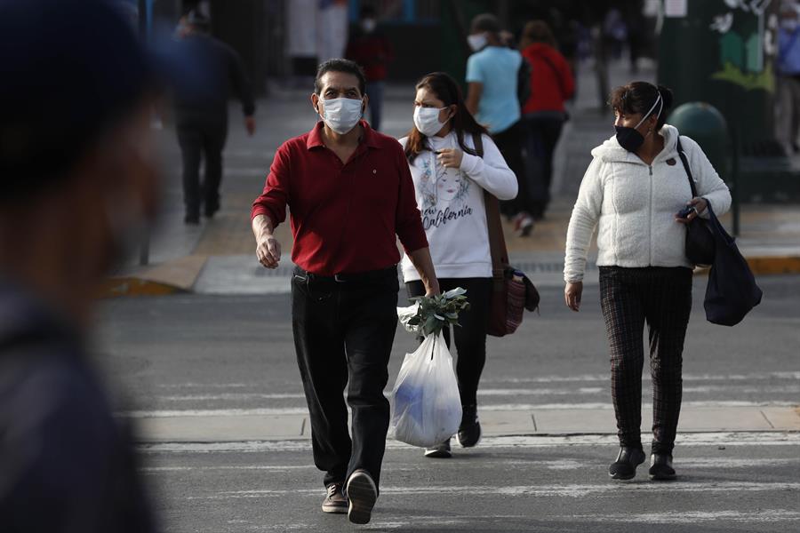 Peruanos con cubrebocas caminan por las calles de Lima. (EFE)
