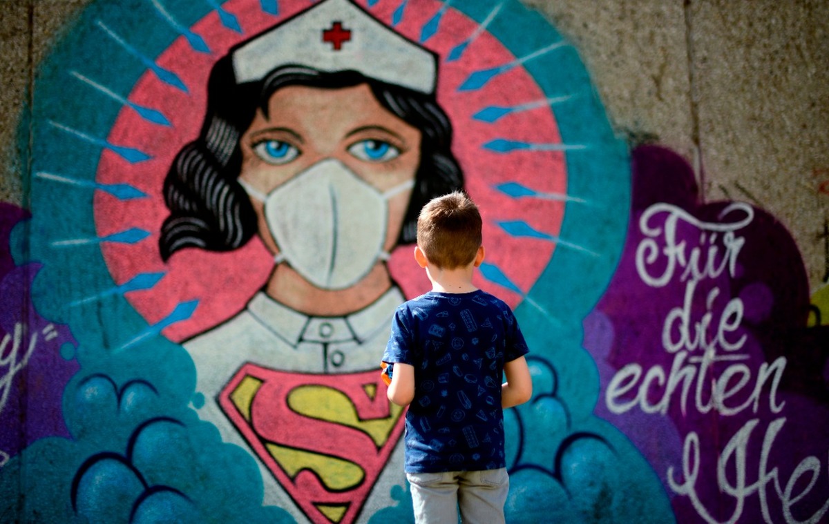 Alemania, un niño observa graffiti de una super enfermera. (AFP/Ina Fassbender)