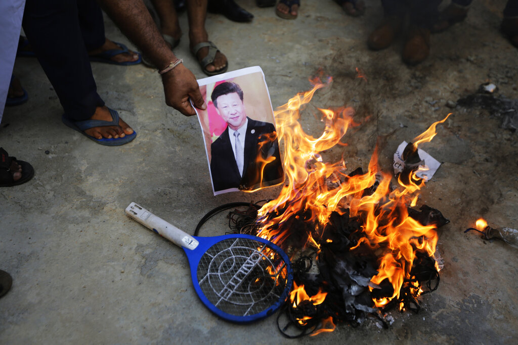 Manifestantes indios queman una foto del presidente chino Xi Jinping por el enfrentamiento militar. (AP)