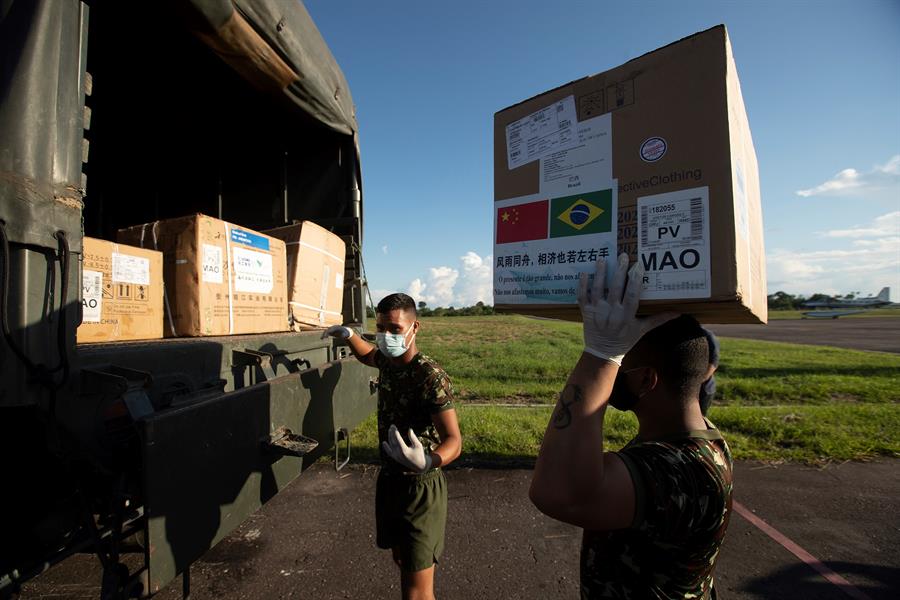 Soldados de las fuerzas armadas de Brasil descargan un avión con asistencia médica. (EFE)