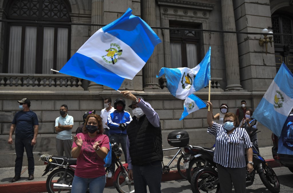 Decenas de personas protestan frene al palacio de gobierno de Guatemala por el manejo de la pandemia. (AFP)