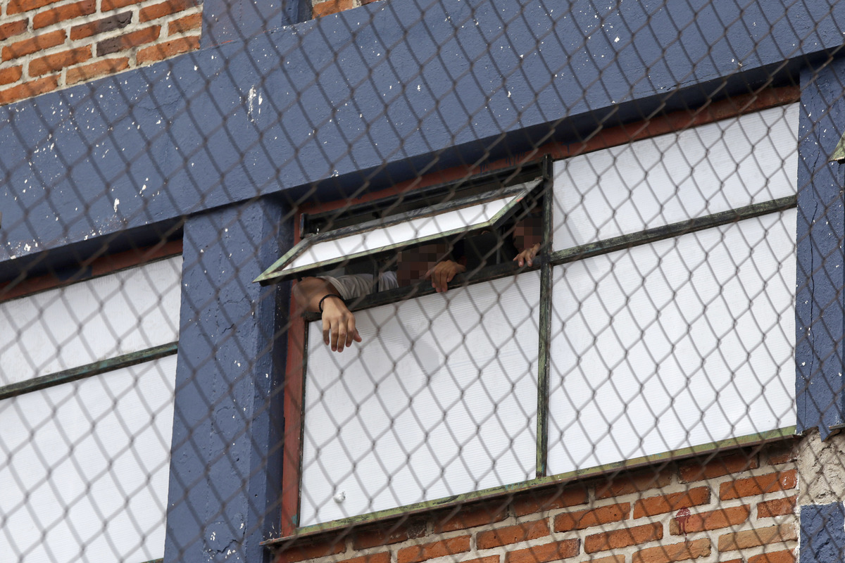 Internos del Centro Penitenciario Temporal covid-19 se asoman por una de las ventanas del CIEPA. (Agencia Enfoque)