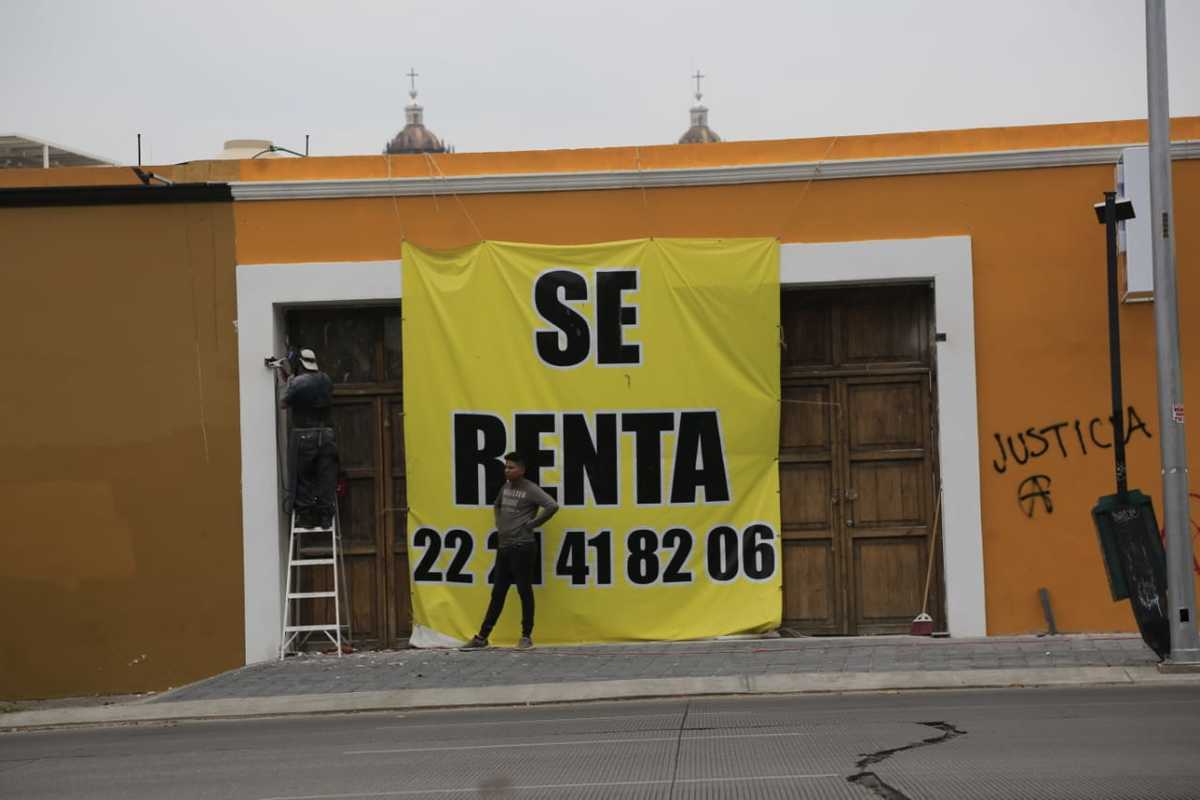 Trabajadores colocan una lona de se renta en un local donde recientemente quebró un negocio por la pandemia. (Andrés Lobato)