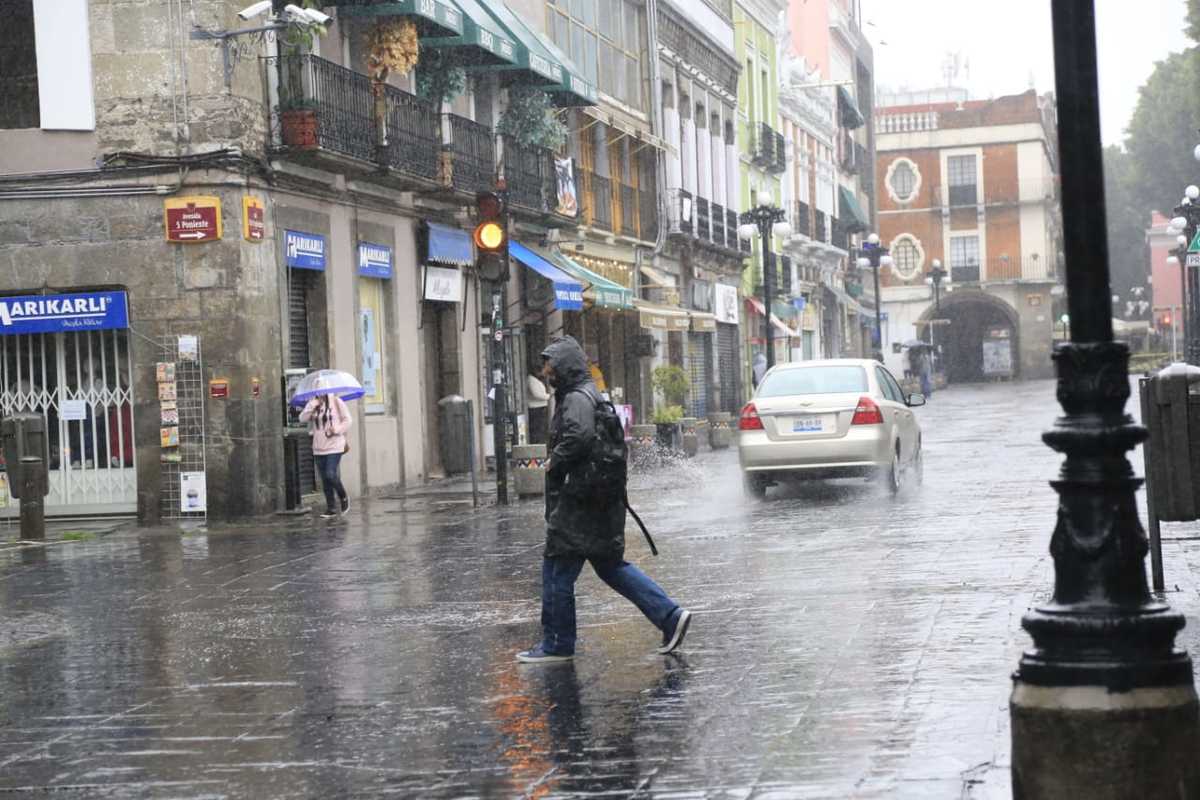 En días de Nueva Normalidad, personas salen a la calle a pesar de la pertinaz lluvia con la que amaneció la capital poblana. (Andrés Lobato)