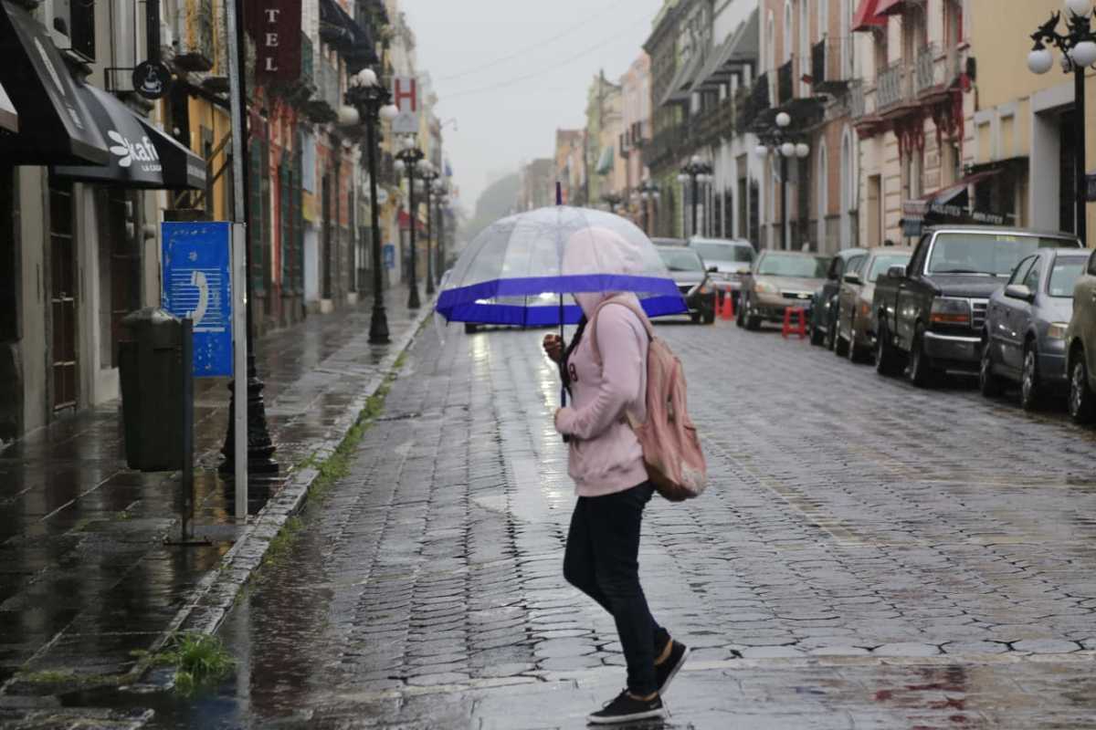En días de Nueva Normalidad, personas salen a la calle a pesar de la pertinaz lluvia con la que amaneció la capital poblana. (Andrés Lobato)