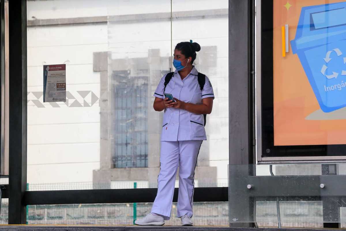 Una enfermera espera por el transporte público en el paradero del RUTA. (Andrés Lobato)