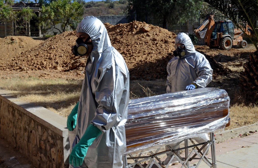 Trabajadores llevan el ataúd de un difunto por coronavirus a un panteón en Cochabamba, Bolivia. (AFP)