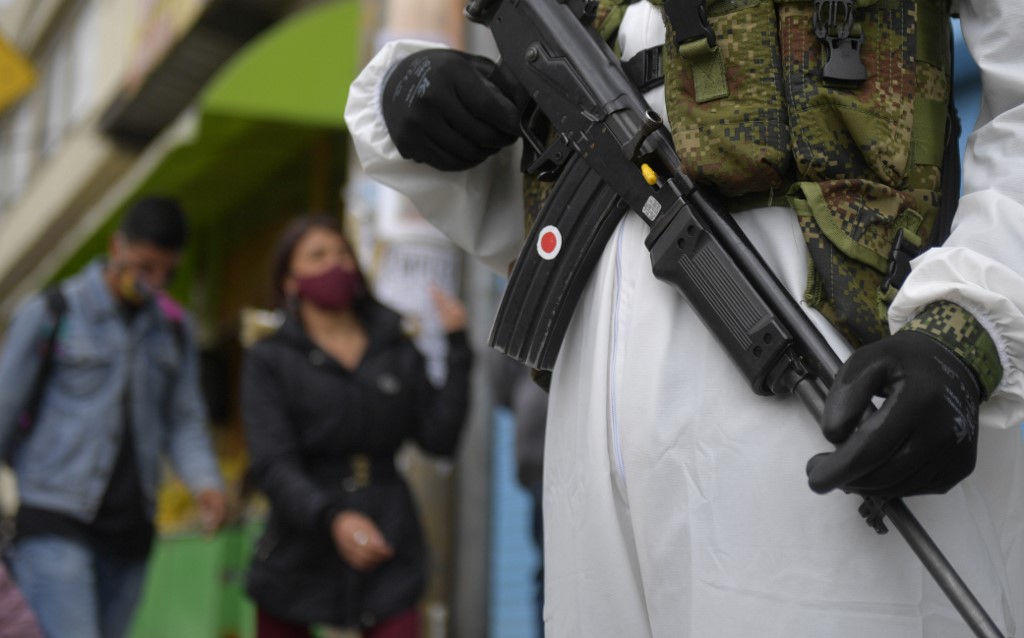 Mientras en Bogotá, soldados colombianos realizan patrullajes, en otras zonas del país son grupos armados ilegales quienes refuerzan la cuarentena. (A