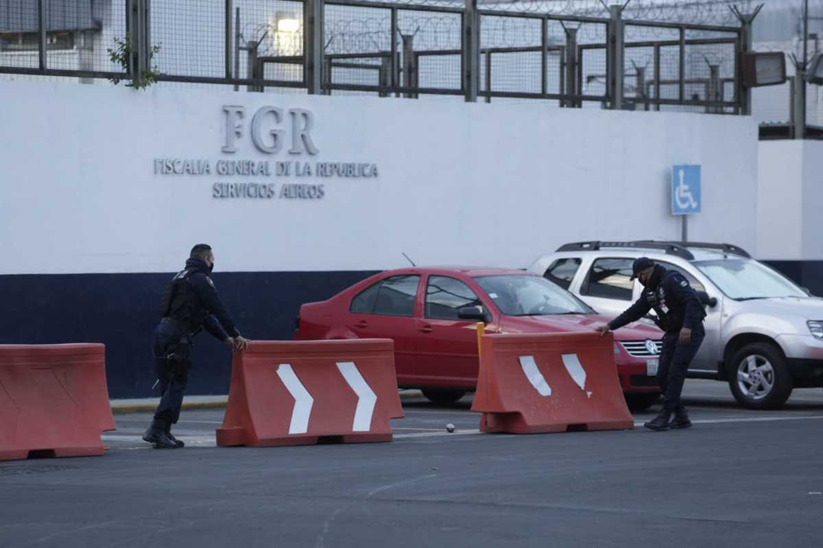 Personal de seguridad comienza a delimitar la zona alrededor del hangar de la FGR ante llegada de Lozoya. (Omar Franco)