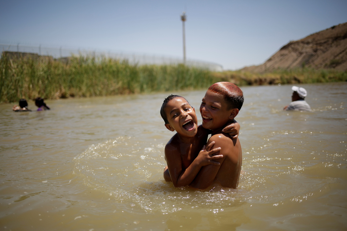 Dos niños se refrescan en el lado mexicano del río Bravo cerca de la frontera con Estados Unidos. (Reuters)