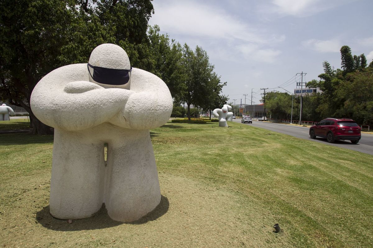 Se colocaron cubrebocas en las esculturas de mármol “Los Gigantes” del artista Daniel Serna. (Cuartoscuro)