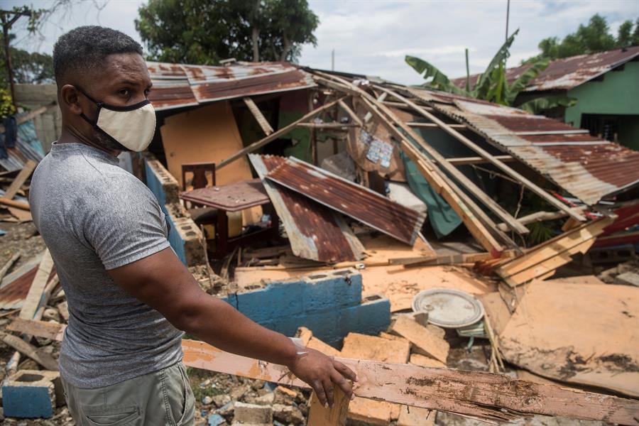 Un hombre dominicano se para al lado de su casa, destruida por el huracán 'Isaías'. (EFE)