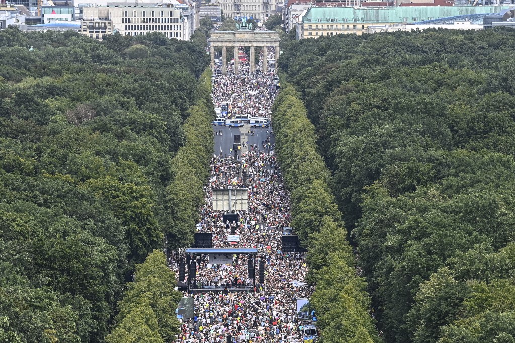 Miles de personas se reunieron frente a la Puerta de Brandeburgo en Berlín contra el confinamiento por el covid-19. (AFP)