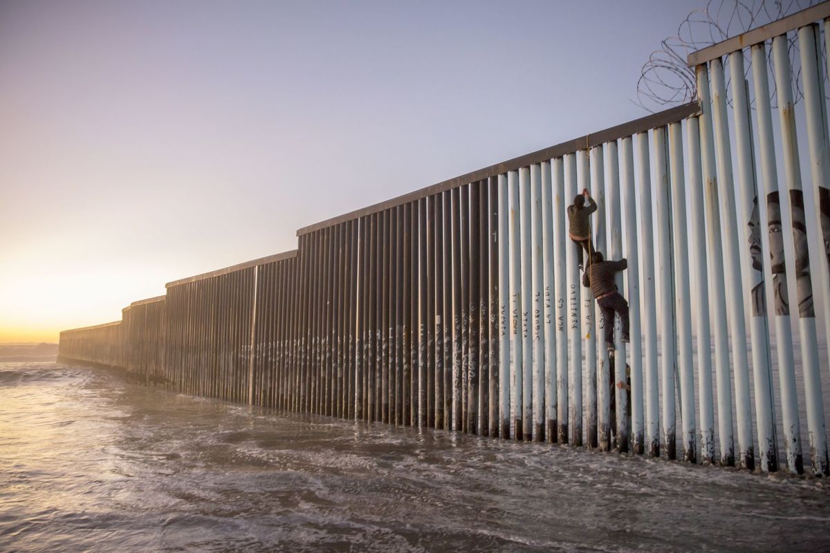 Migrantes a un costado del muro fronterizo entre México y Estados Unidos. (Cuartoscuro)