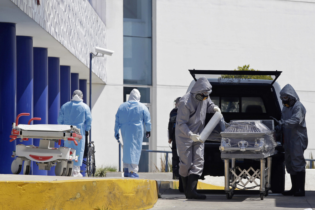 Personal de una funeraria realiza el traslado de una persona fallecida a causa de covid-19 en el Hospital General de Cholula. (Agencia Enfoque)