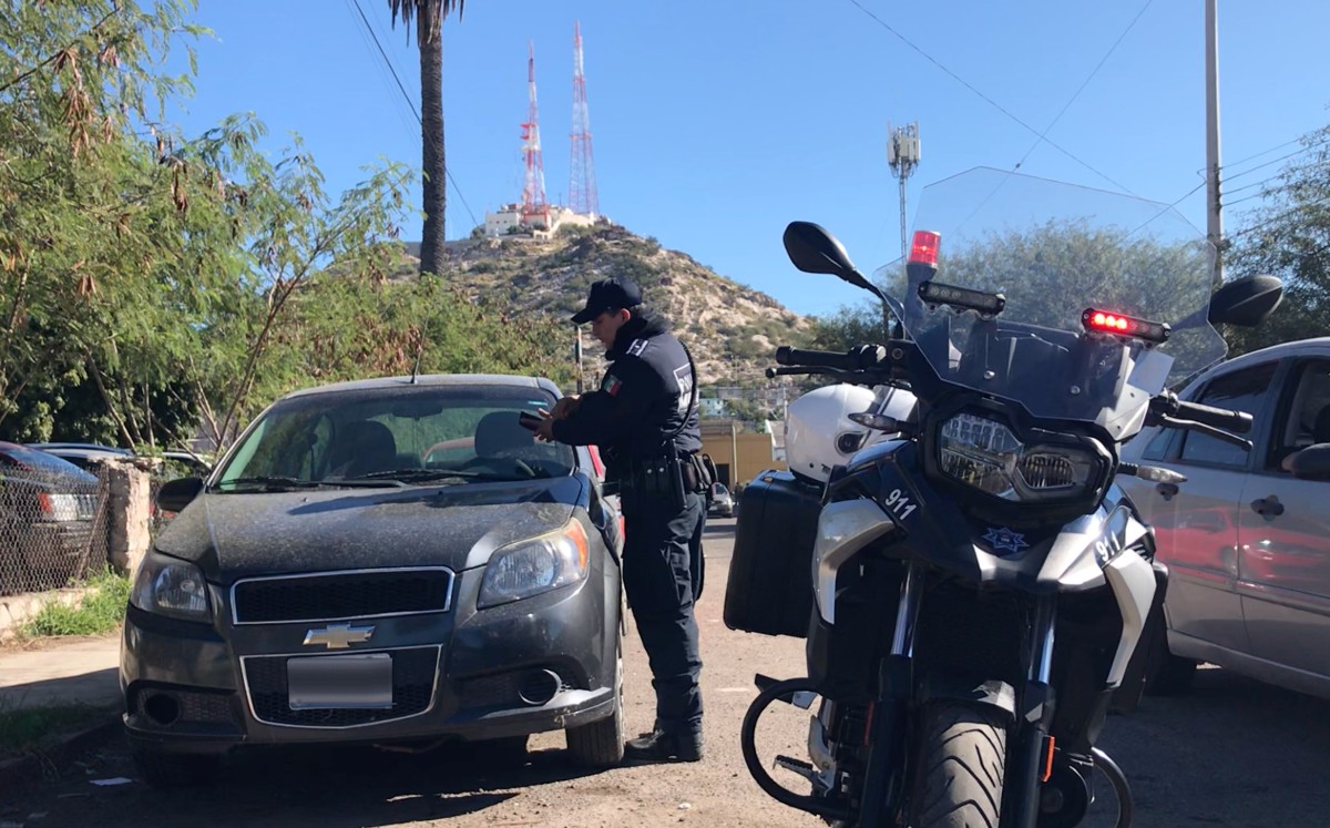 Un policía de Tránsito Municipal multa a un vehículo en el primer cuadro de la ciudad de Hermosillo. (Alberto Moreno Olguín)