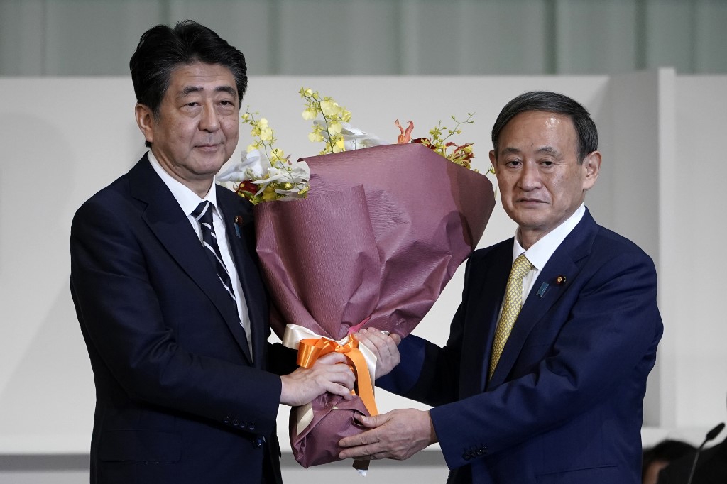 Yoshihide Suga junto al primer ministro Shinzo Abe en la nominación del PLD de Japón. (AFP)