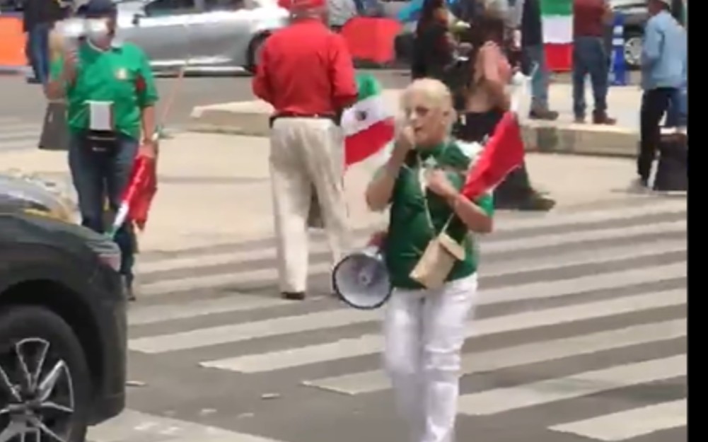 Con un megáfono, la mujer pide voluntarios para ocupar las casas de campaña. (Especial)