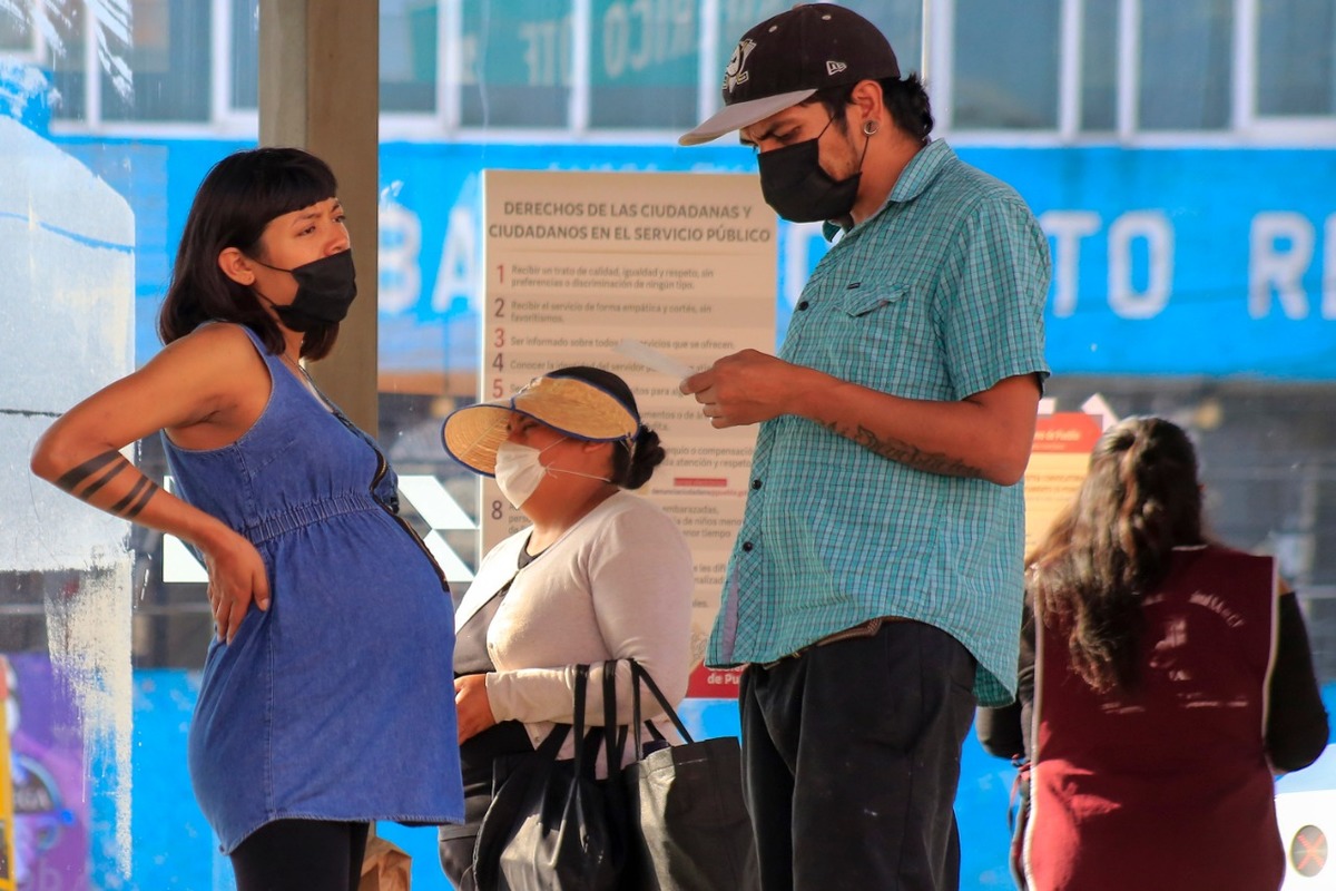 Una mujer embarazada y un hombre esperan el camión en la estación del RUTA. (Andrés Lobato)