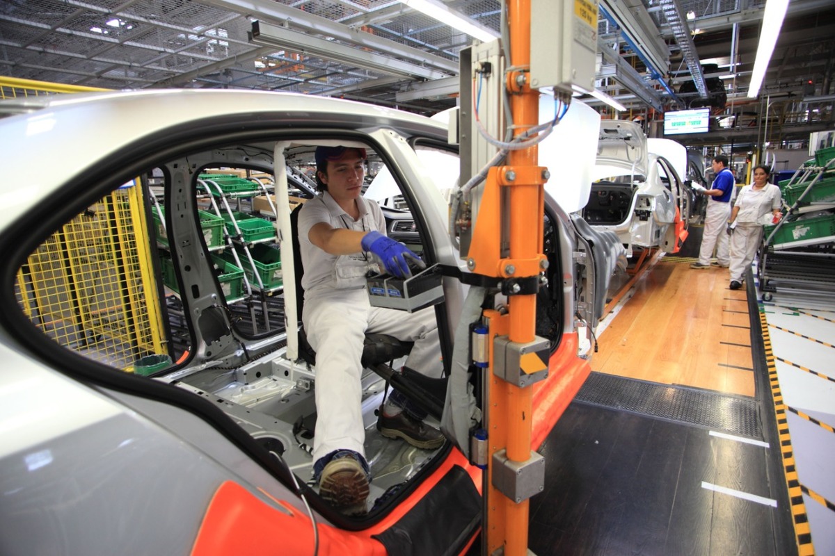 Un trabajador de la industria automotriz detalla la parte interior de un vehículo en la línea de producción. (Andrés Lobato)