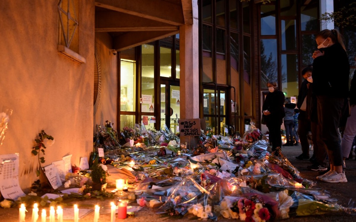 En Francia, personas dejan flores y velas en la escuela donde fue asesinado el profesor Samuel Paty. (EFE)