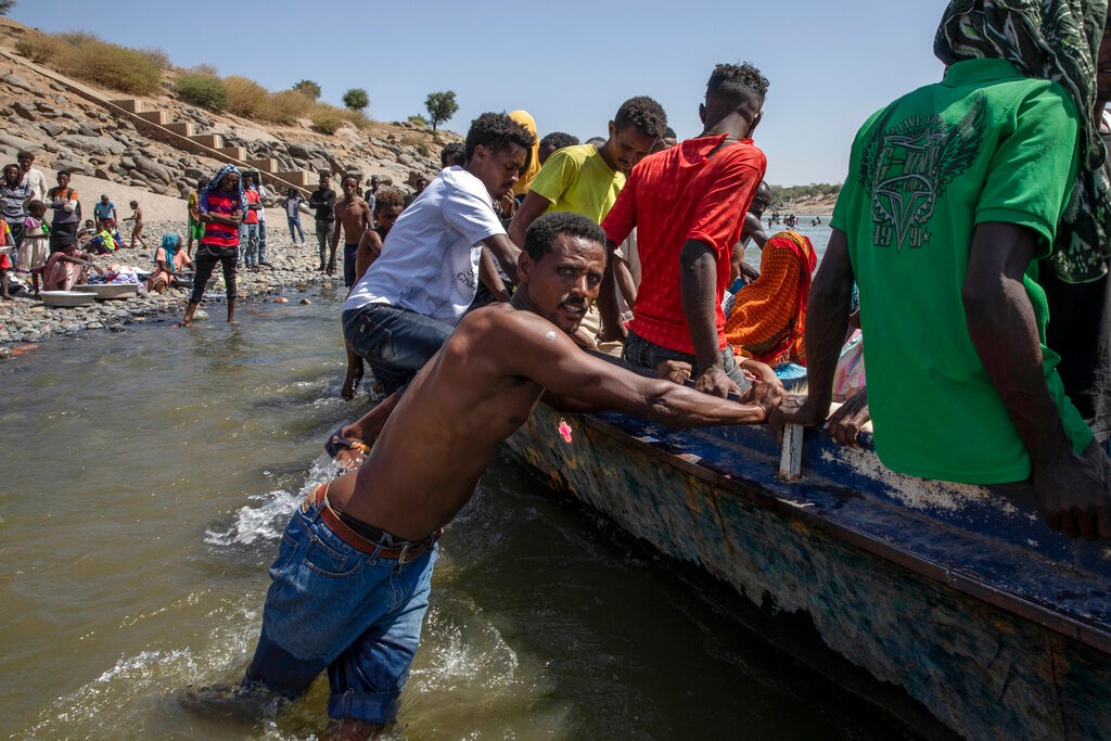 Refugiados del conflicto en torno a la región de Tigray en Etiopía cruzan el río Tekeze en la frontera entre Sudán y Etiopía. (Agencia AP)