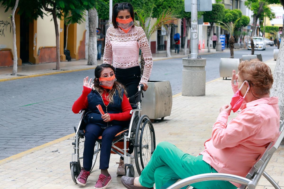 Personas con 'cubrebocas incluyente' en Puebla, denominado así por sus creadoras del grupo Incluyeteh. (Cuartoscuro)