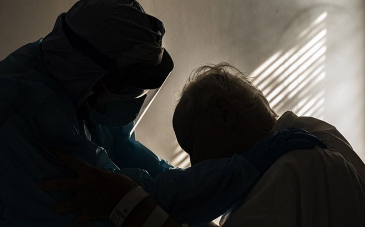 La foto de un médico abrazando a un anciano con covid-19 se vuelve viral. (AFP)