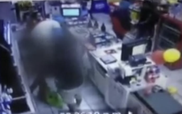 Uno de los delincuentes  golpea a un cliente que se disponía a pagar.