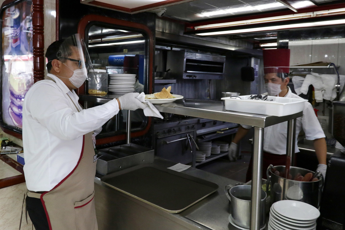 Meseros laboran en un restaurant con medidas para prevenir contagios de covid-19. (Agencia Enfoque)