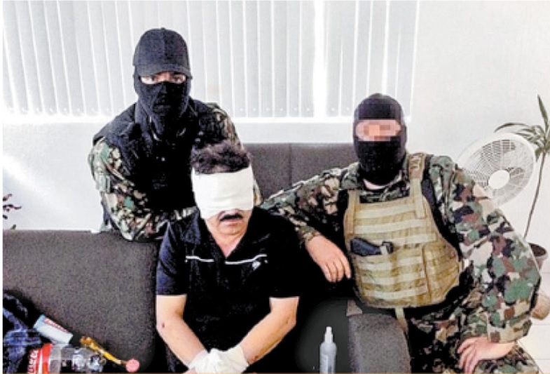 El elemento de la DEA con uniforme de la Marina mexicana sentado junto a 'El Chapo'. (Especial)