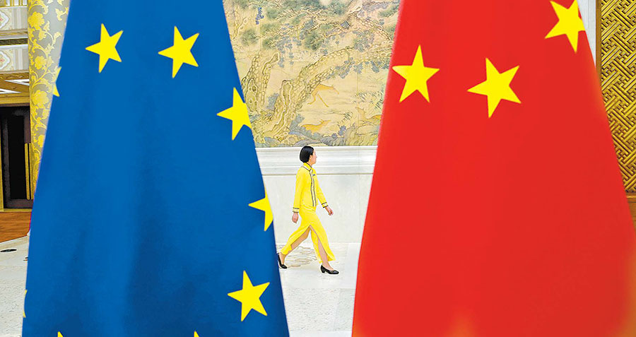 Un asistente pasa junto a las banderas de la Unión Europea y China antes del Diálogo Económico de Alto Nivel en Pekín. (Jason Lee/Reuters)