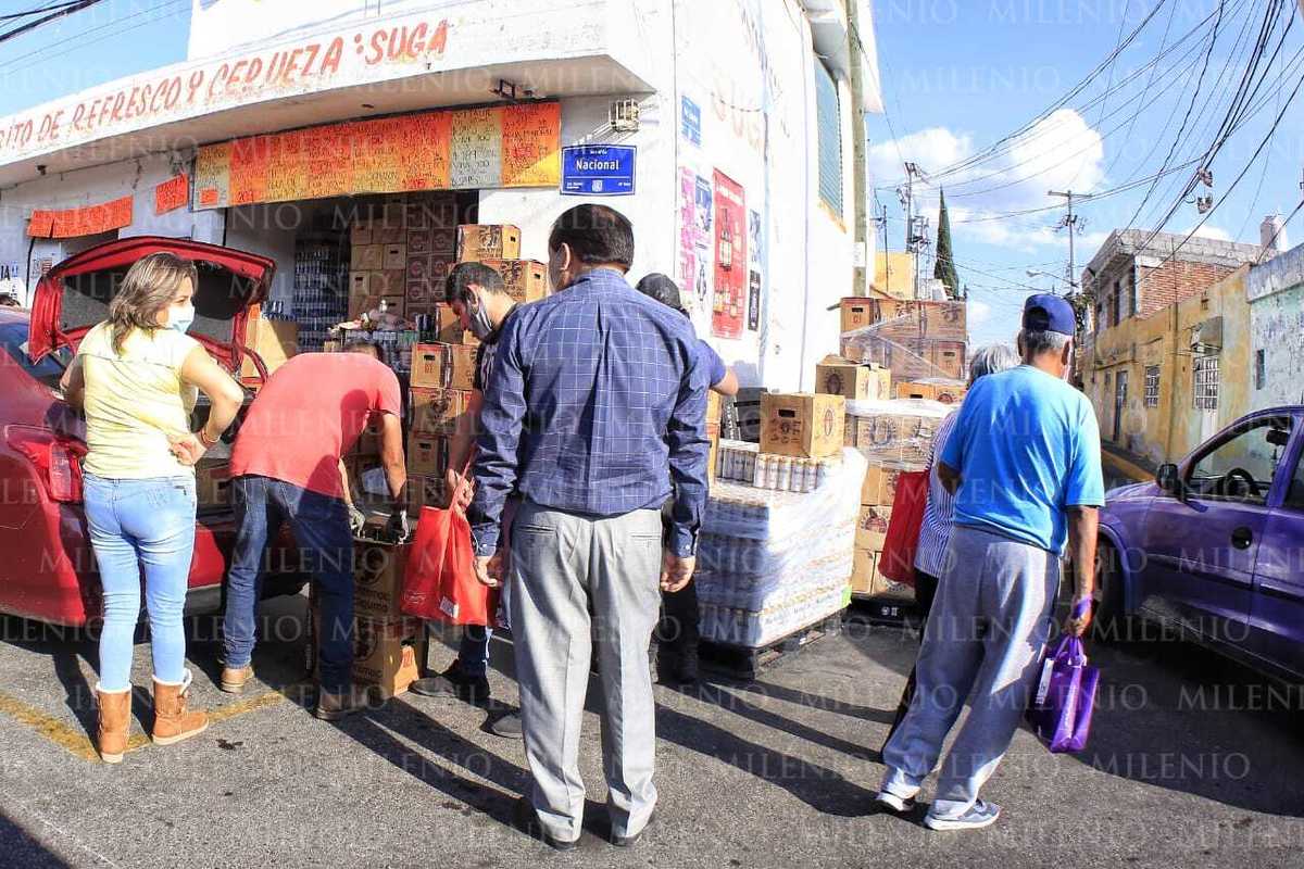 Decenas de personas hacen fila sin guardar la sana distancia para comprar bebidas alcohólicas. (Andrés Lobato)