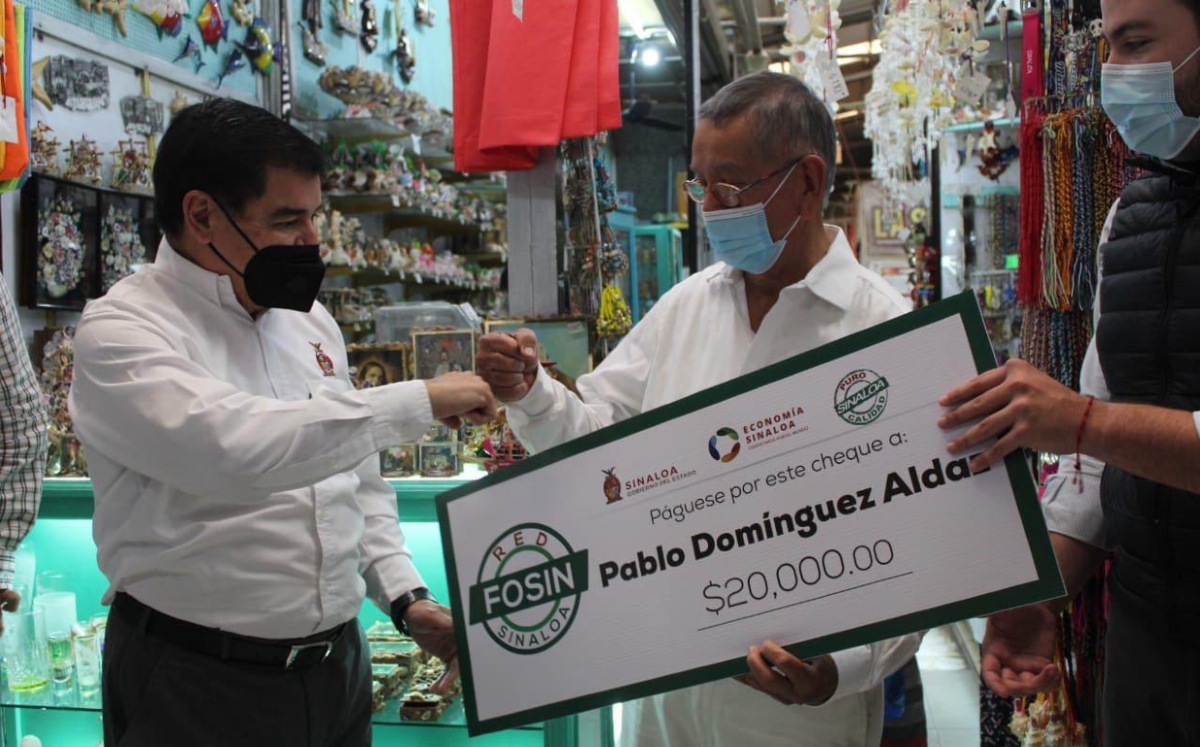 El secretario de economía estatal haciendo entrega de un cheque. (Especial)
