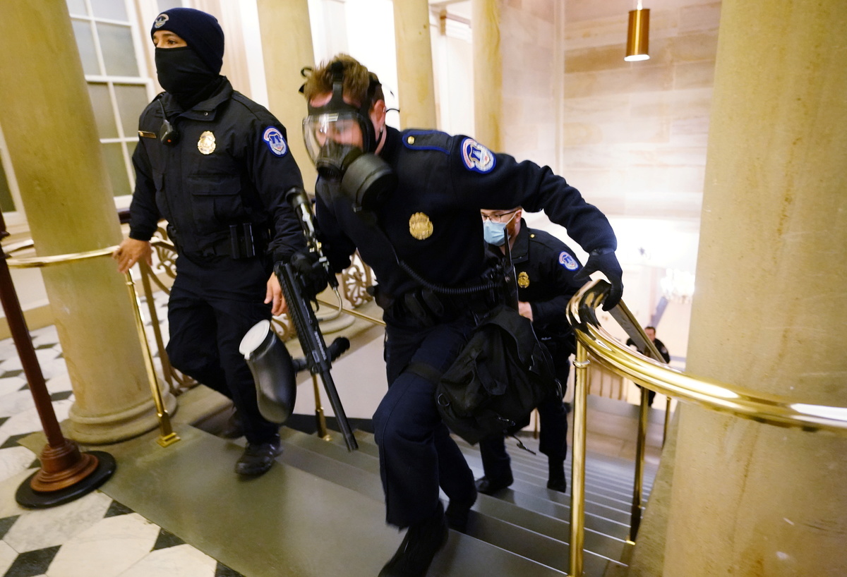 Los oficiales de policía del Capitolio de EU toman posiciones cuando los manifestantes ingresan al edificio del Capitolio | Reuters