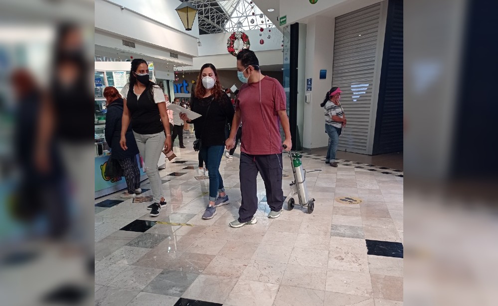 Captan a hombre caminando por centro comercial y con tanque de oxígeno