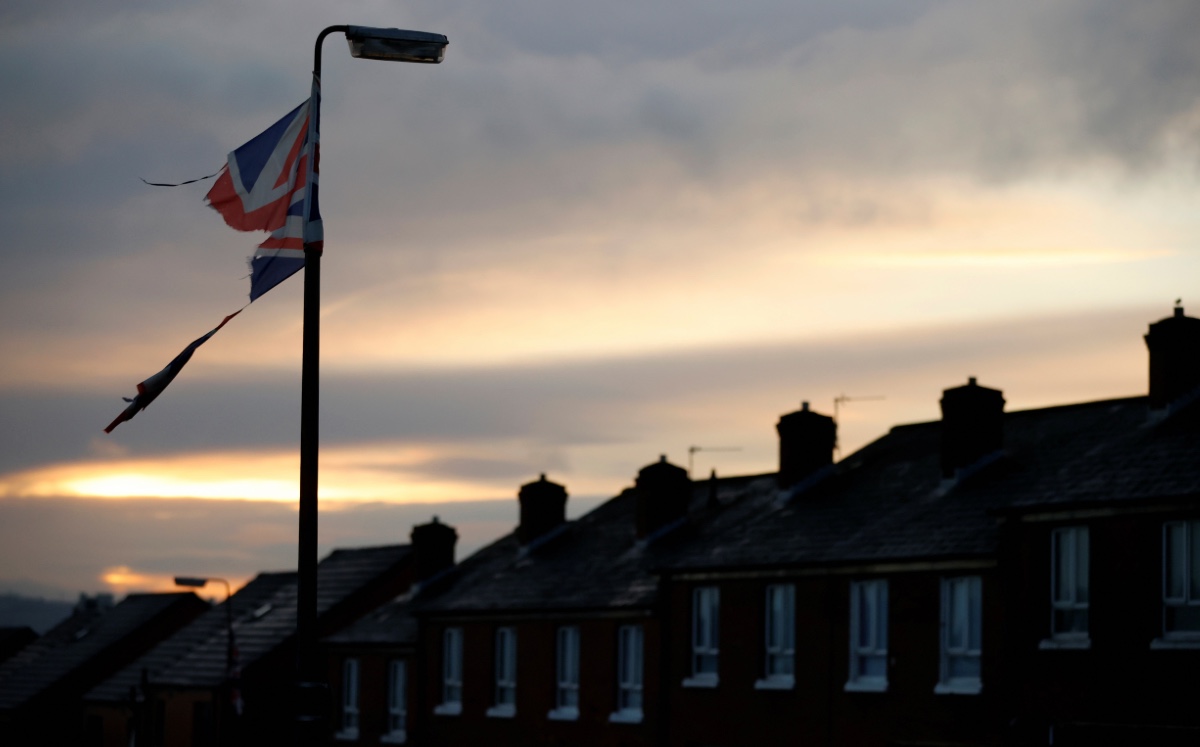 Una bandera de Union Jack rota cuelga de un poste de luz en una calle con terrazas en Belfast, Irlanda del Norte. (Reuters)