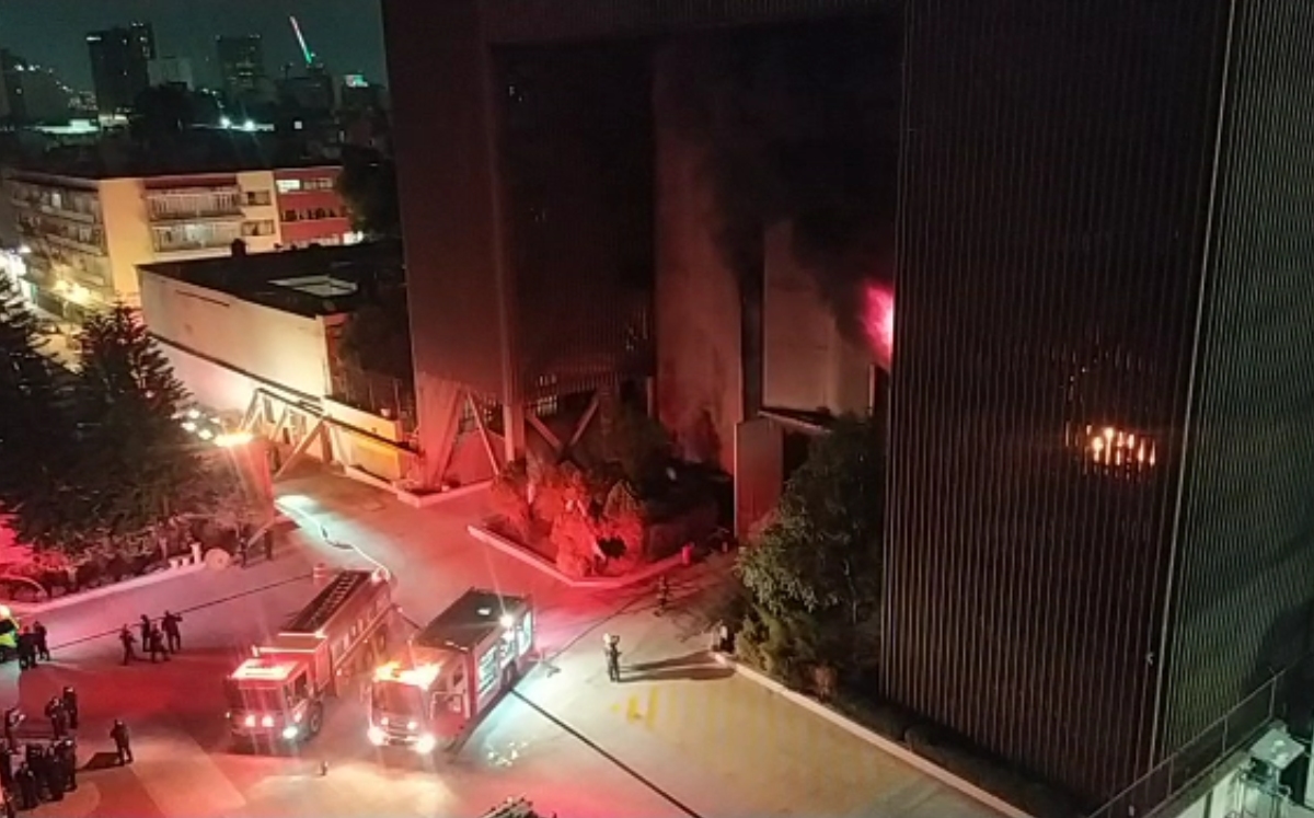 Los bomberos realizan esfuerzos para controlar las llamas en el edificio. (Especial)
