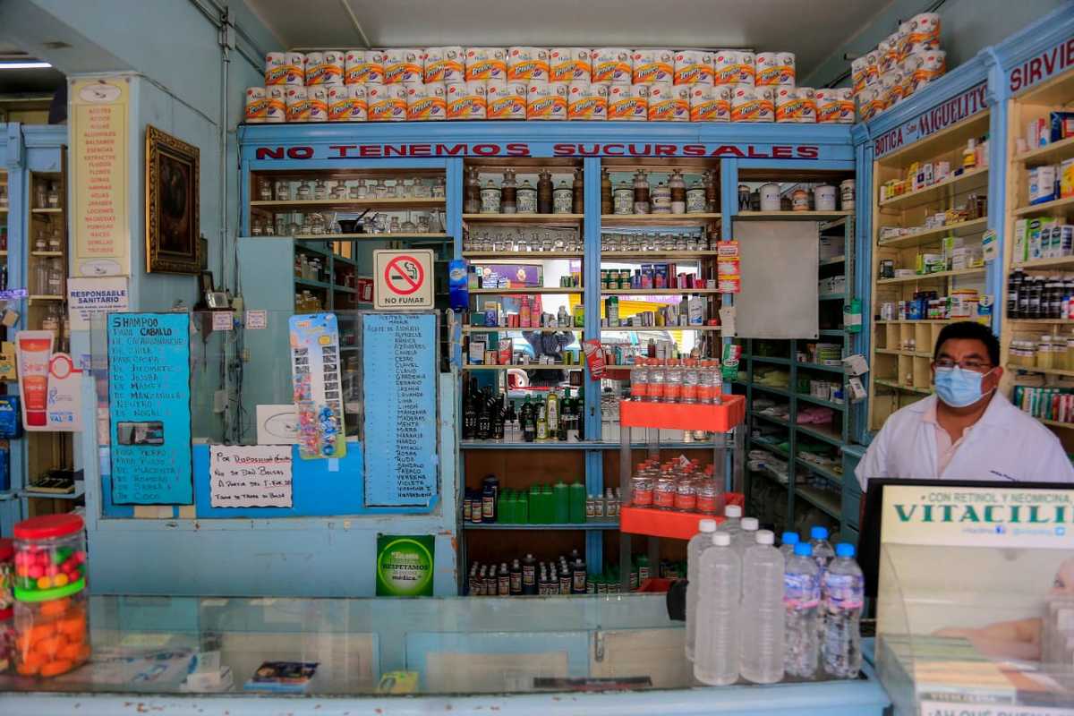 Un trabajador atiende al interior de una farmacia en el Centro Histórico de Puebla. (Andrés Lobato)