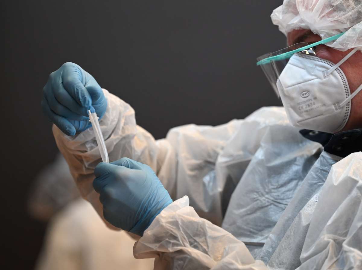 Un trabajador de la salud sostiene la prueba covid que acaba de realizar.  Foto: Denis Charlet/AFP
